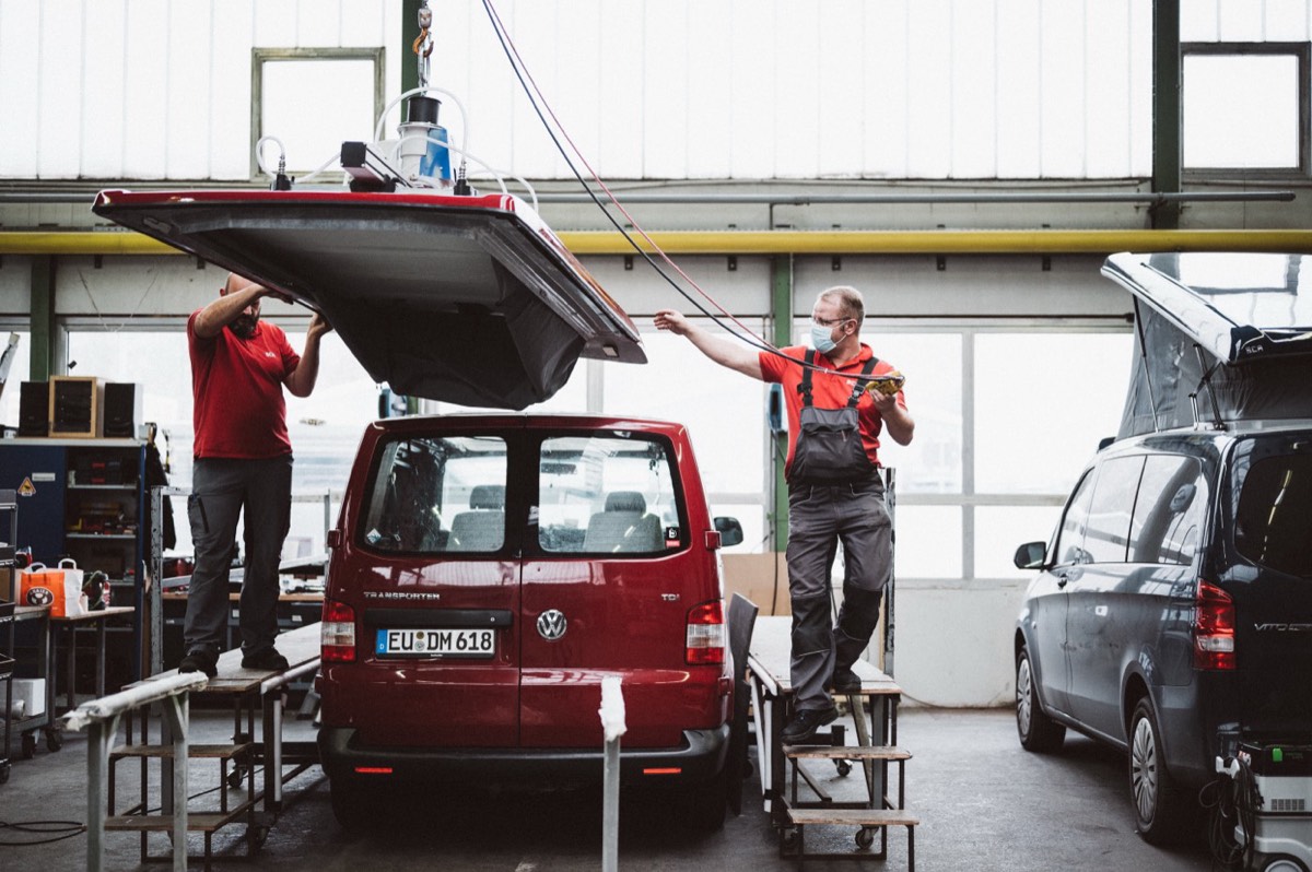 Das neue SCA-Aufstelldach wird beim Einbau auf den VW T5 gesetzt