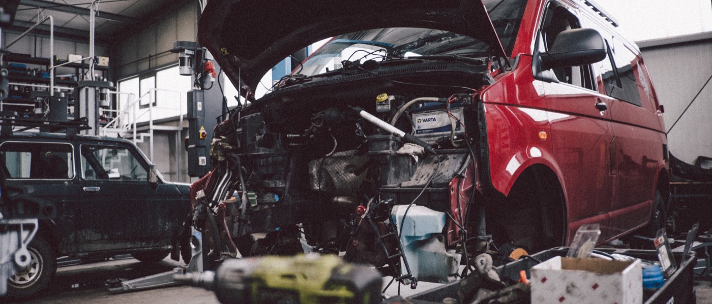 Roter VW T5 mit geöffneter Front in der Werkstatt